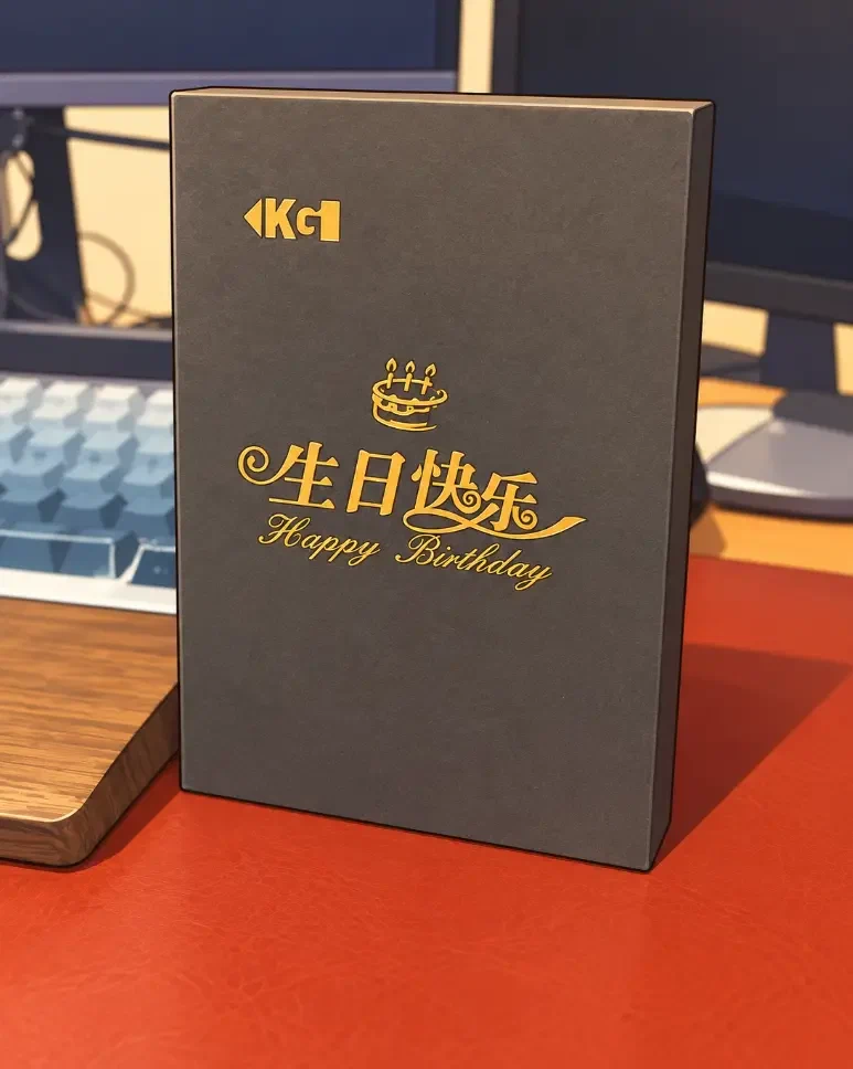 公司赠送的生日礼盒，深灰色封面上印着金色的生日祝福