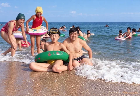 约1993年6月,十五岁的我戴着潜水镜、套着绿色游泳圈,与四十二岁的父亲坐在北戴河海边